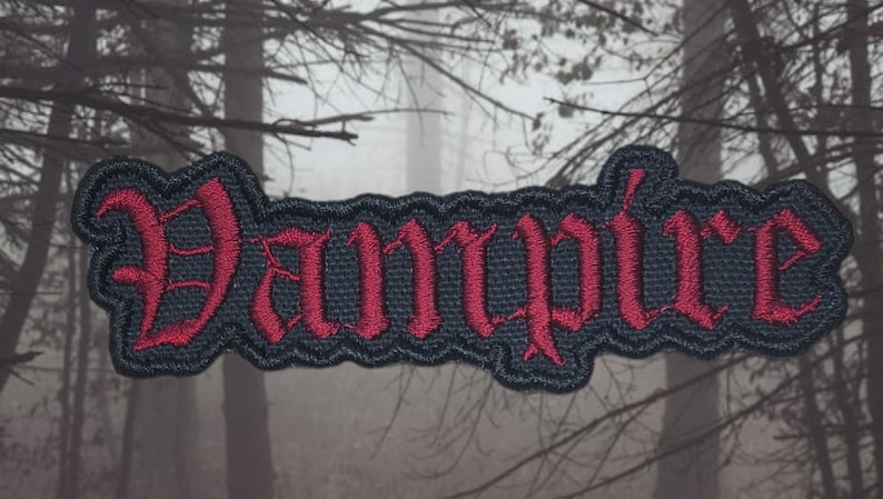 May include: Black embroidered patch with the word "Vampire" in red lettering. The patch has a slightly distressed look and is perfect for adding a gothic touch to clothing or bags.