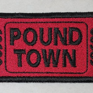 May include: Red and black embroidered patch with the text "POUND TOWN" in a ticket-style design.