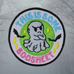 May include: A white, green, and pink embroidered patch with a ghost and the text "This is some boosheet".