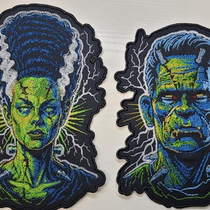 May include: Two embroidered patches featuring the Bride of Frankenstein and Frankenstein's monster. Both designs showcase vibrant green and blue thread work, detailed facial features, and white lightning bolt accents against a black background.