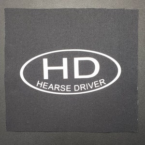 May include: Black fabric patch with a white oval containing the letters "HD" and the text "HEARSE DRIVER".