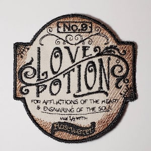 May include: A brown and black embroidered patch with the text "Love Potion No. 9" and the words "For Afflictions of the Heart & Ensnaring of the Soul".