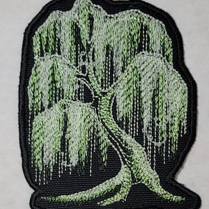 May include: An embroidered patch of a weeping willow tree with green and white thread on a black background.