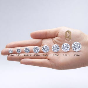 May include: A hand displays a series of eight round-cut diamonds, ranging in size from 0.20 ct to 0.90 ct. Each diamond is labeled with its carat weight. The image includes the text "GRAPHIC JEWELS SINCE 2025".