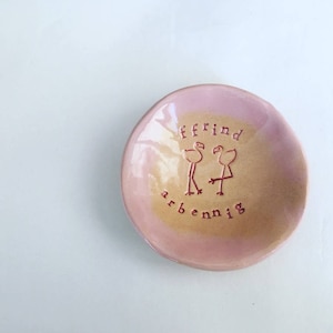 Peut inclure: Un petit plat en céramique rose et jaune avec un motif peint à la main de deux flamants roses et les mots "ffrind arbennig".