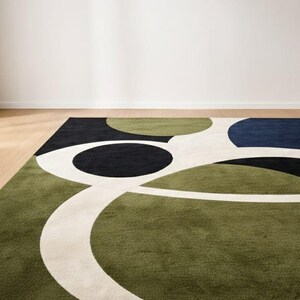 May include: A modern area rug with an abstract design. The rug features a green, black, navy blue, and white color palette. The design includes large circular and curved shapes. The rug is placed on a hardwood floor.