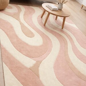 floor covering with wavy pattern
calming color palette area rug
living room centerpiece rug
modern decor rug with pastel tones
cozy wool rug for daily use
artistic rug with flowing curves
neutral modern rug for home
soft pastel rug for calm interiors
luxury hand tufted carpet
contemporary abstract rug design
elegant wool rug for home
modern interior styling rug