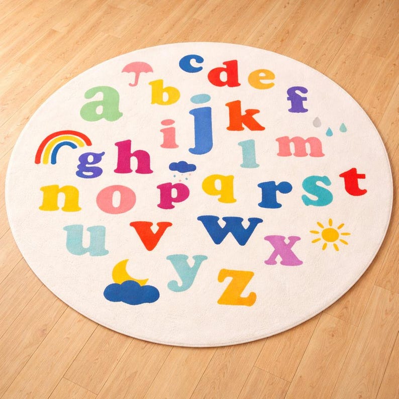 May include: A round, off-white rug featuring the alphabet in various bright colors. Each letter is distinct, with accompanying illustrations like a rainbow, sun, and cloud. The rug is designed for a child's room or play area.