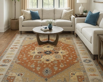 Puede incluir: Una alfombra rectangular que presenta un gran medallón central de color naranja quemado rodeado por un campo color canela con intrincados patrones florales y geométricos en tonos azul, crema y gris, con un borde decorativo y flecos cortos.