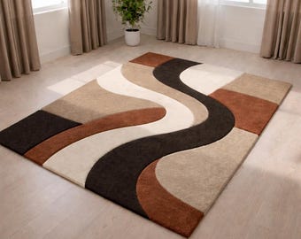 Può includere: Un tappeto rettangolare con un design ondulato nei toni del marrone, beige e crema. Il tappeto presenta un'onda centrale marrone scuro che si snoda sulla superficie, creando un aspetto moderno ed elegante. Il tappeto è realizzato in un materiale morbido e felpato.
