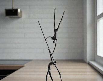 Iron statue of a man holding a pole with a figure above him | Metal art | Home decoration