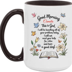 Może przedstawiać: Biały ceramiczny kubek z czarnym uchwytem i obramowaniem. Kubek zawiera napis "Good Morning Camila" z kwiatowym i motylowym wzorem. Zawiera również tekst "This is God, I will be handling all of your problems today".