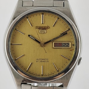 Vintage Seiko 5 automatisch 21 juwelen gouden wijzerplaat cal. 7019 dag en datum roestvrijstalen band onlangs service heren polshorloge