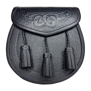 May include: Black leather sporran with a Celtic knot design on the flap. The sporran has three black tassels hanging from the bottom. The pouch is oval-shaped and has a textured surface.