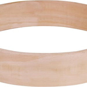 May include: A light-colored, unfinished wooden embroidery hoop. The hoop is circular, with a smooth, curved surface. The wood grain is visible, and the hoop appears to be made of a single piece of wood. The hoop is approximately 10 inches in diameter.