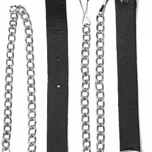 May include: Black leather kilt straps with silver-tone metal chains and hardware. The straps have a pointed end and are secured with rivets and buckles. The chains have a hook and ring attachment.