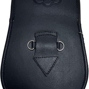 May include: A black leather sporran with a decorative embossed floral design at the top. The sporran features a flap with a stitched diamond shape and two metal D-rings for attachment.