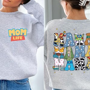 a woman wearing a sweatshirt that says mom life