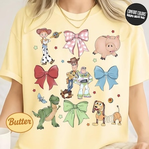 a yellow t-shirt with a collage of cartoon characters from the Toy Story franchise, including characters like Buzz Lightyear, Woody, and a pig.