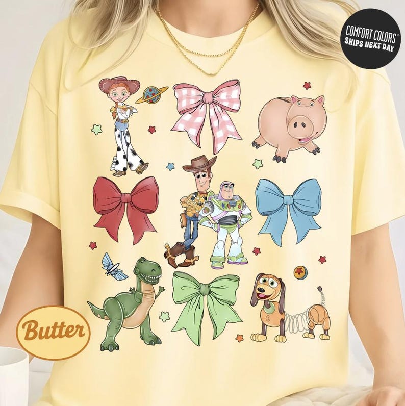 a yellow t-shirt with a collage of cartoon characters from the Toy Story franchise, including characters like Buzz Lightyear, Woody, and a pig.