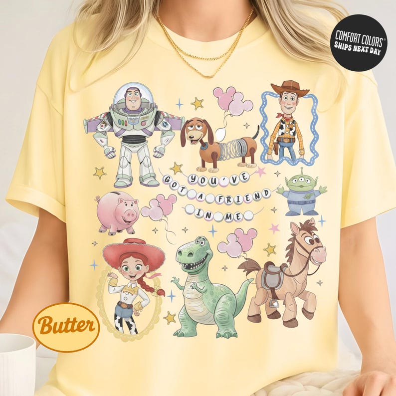 A yellow t-shirt with a collage of various cartoon characters from the Toy Story franchise, including Buzz Lightyear, Woody, and other beloved characters.