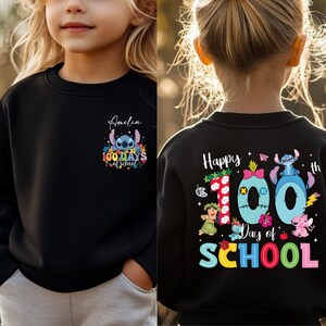 A young girl wearing a black sweater with a colorful design and text on the back.