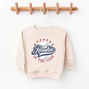 a baseball sweatshirt hanging on a wooden hanger
