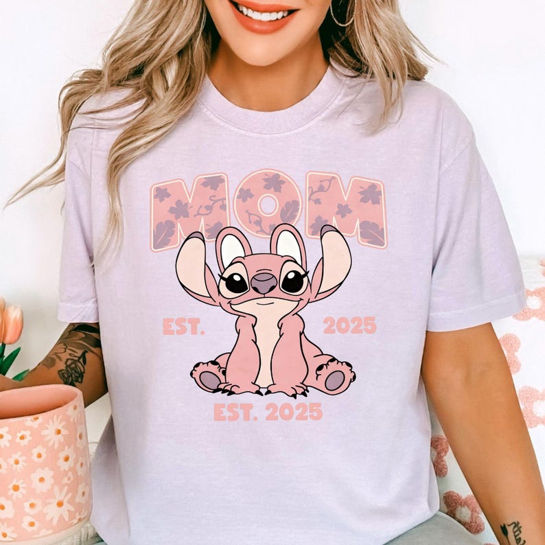 A woman wearing a t-shirt with a cartoon character and text printed on it.