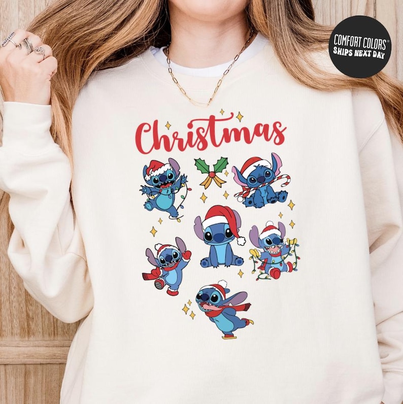 A woman wearing a white sweatshirt with a Christmas-themed design featuring cartoon characters of Stitch from the Lilo & Stitch movie.