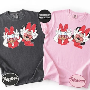 two t-shirts with Minnie Mouse designs, one in black and one in pink.