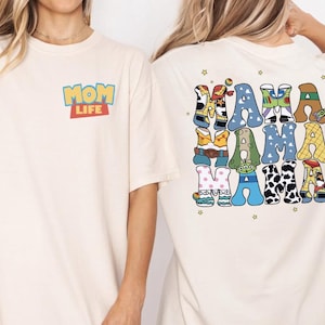 Two women wearing white t-shirts with colorful text and characters on the back.