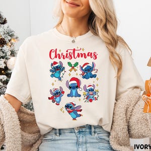 A woman wearing a white t-shirt with a Christmas-themed design featuring cartoon characters.
