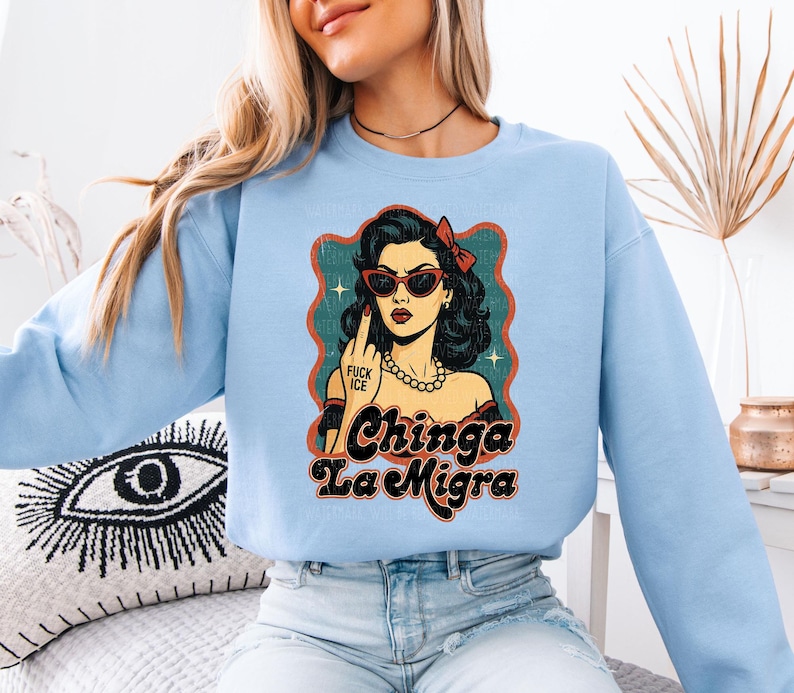 a woman wearing a blue sweatshirt with a picture of a woman wearing sunglasses