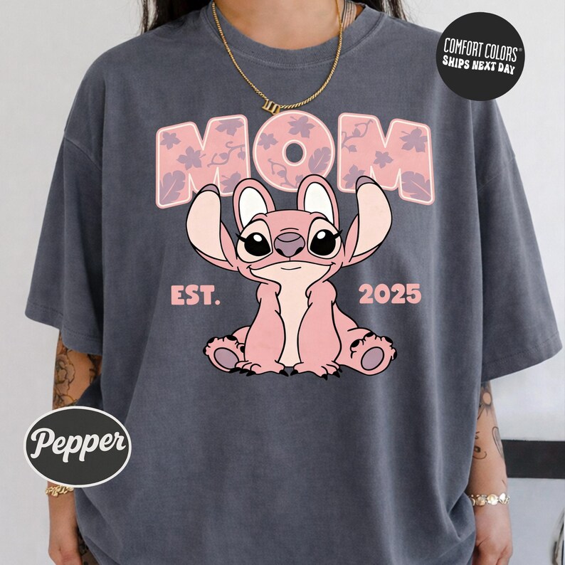 A person wearing a gray t-shirt with a graphic design featuring a cartoon character and text.