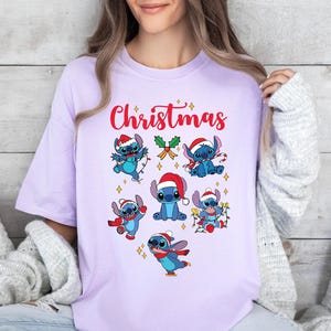 A woman wearing a purple t-shirt with a Christmas-themed design featuring various cartoon characters.