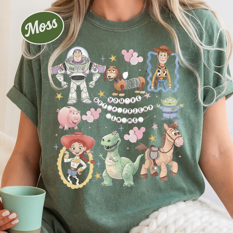 A person wearing a green t-shirt with various cartoon characters and a message printed on it.