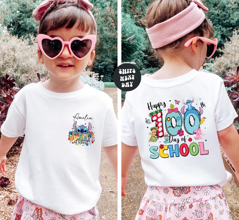 A young girl wearing a white t-shirt with a personalized design and text, standing in a garden setting.
