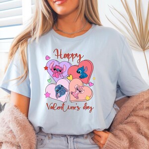 A woman wearing a light blue t-shirt with a graphic design featuring cartoon characters and the text "Happy Valentine's day".
