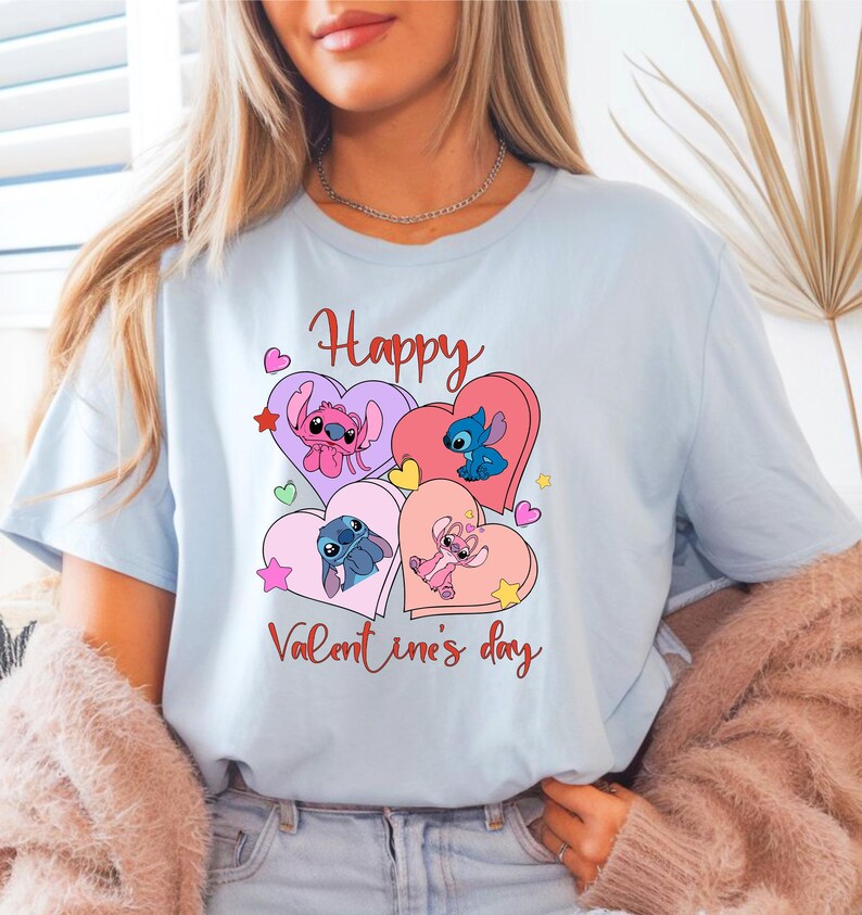 A woman wearing a light blue t-shirt with a graphic design featuring cartoon characters and the text "Happy Valentine's day".