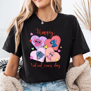 A woman wearing a black t-shirt with a graphic design featuring four cartoon characters and the text "Happy Valentine's day".