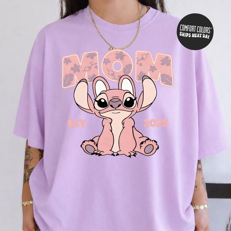 A person wearing a purple t-shirt with a cartoon character and text printed on it.