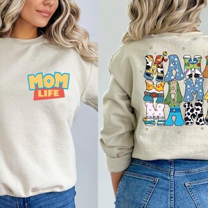 a woman wearing a mom life sweatshirt and jeans