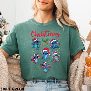 A woman wearing a green t-shirt with a Christmas-themed graphic design featuring various cartoon characters.