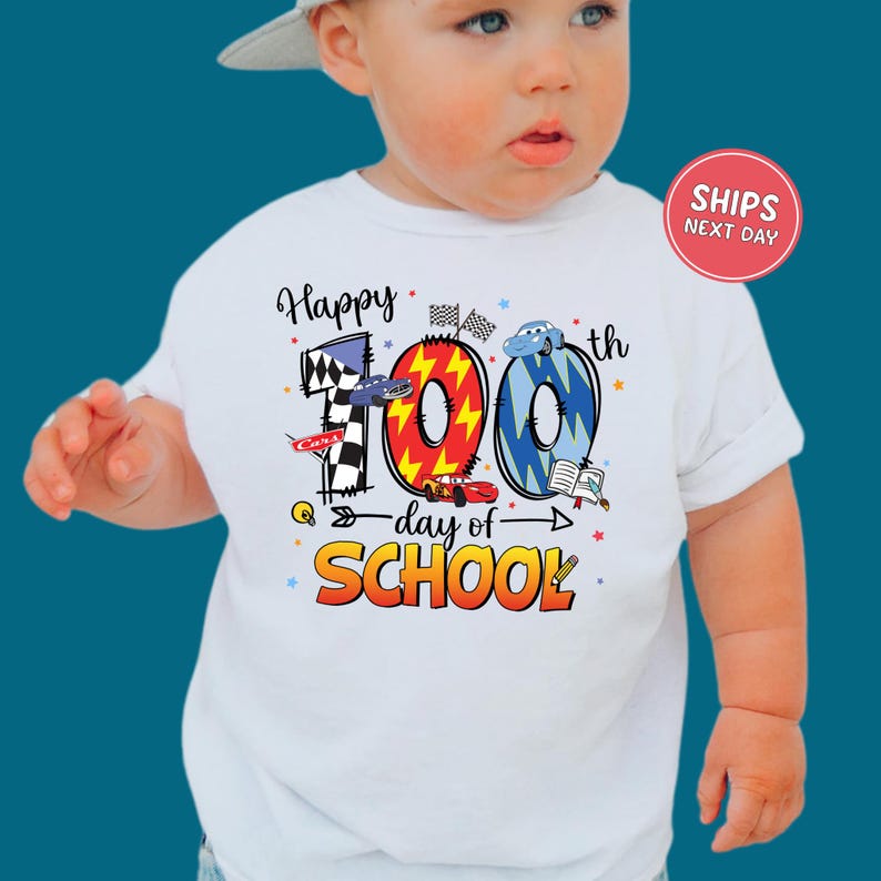 A baby wearing a white t-shirt with a colorful graphic design celebrating the 100th day of school.
