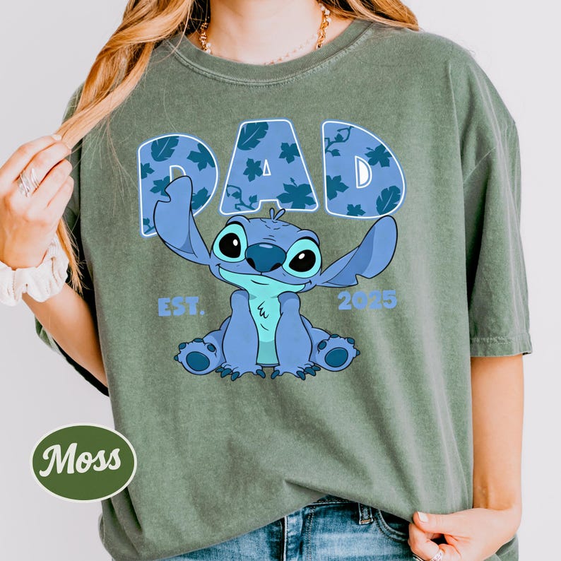 A person wearing a green t-shirt with a graphic design featuring a cartoon character and text.