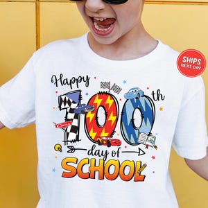 A person wearing a white t-shirt with a graphic design celebrating the 100th day of school.