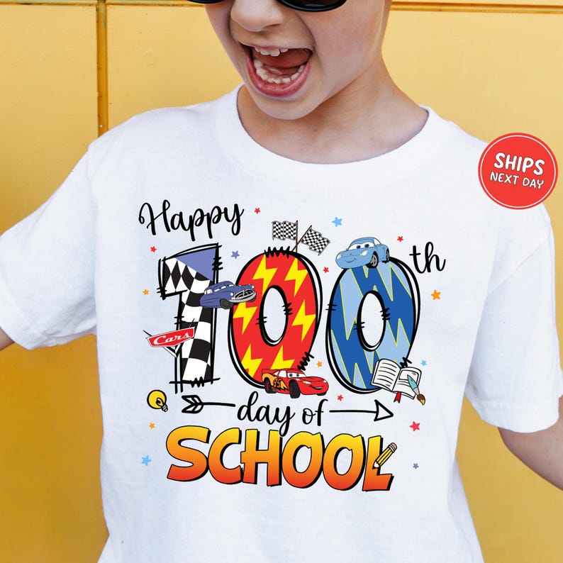 A person wearing a white t-shirt with a graphic design celebrating the 100th day of school.