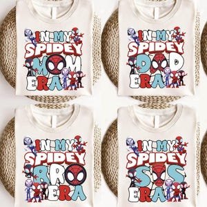 four identical white t-shirts with the text "IN MY SPIDEY" printed on them. The text is surrounded by various Spider-Man characters, including the iconic Spider-Man logo.