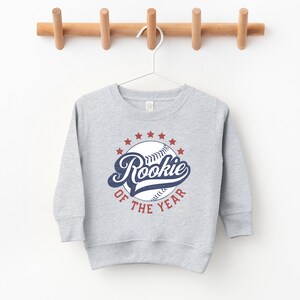a baseball sweatshirt hanging on a wooden hanger