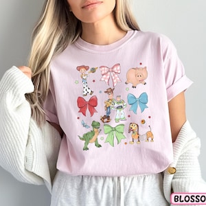 a woman wearing a pink shirt with cartoon characters on it